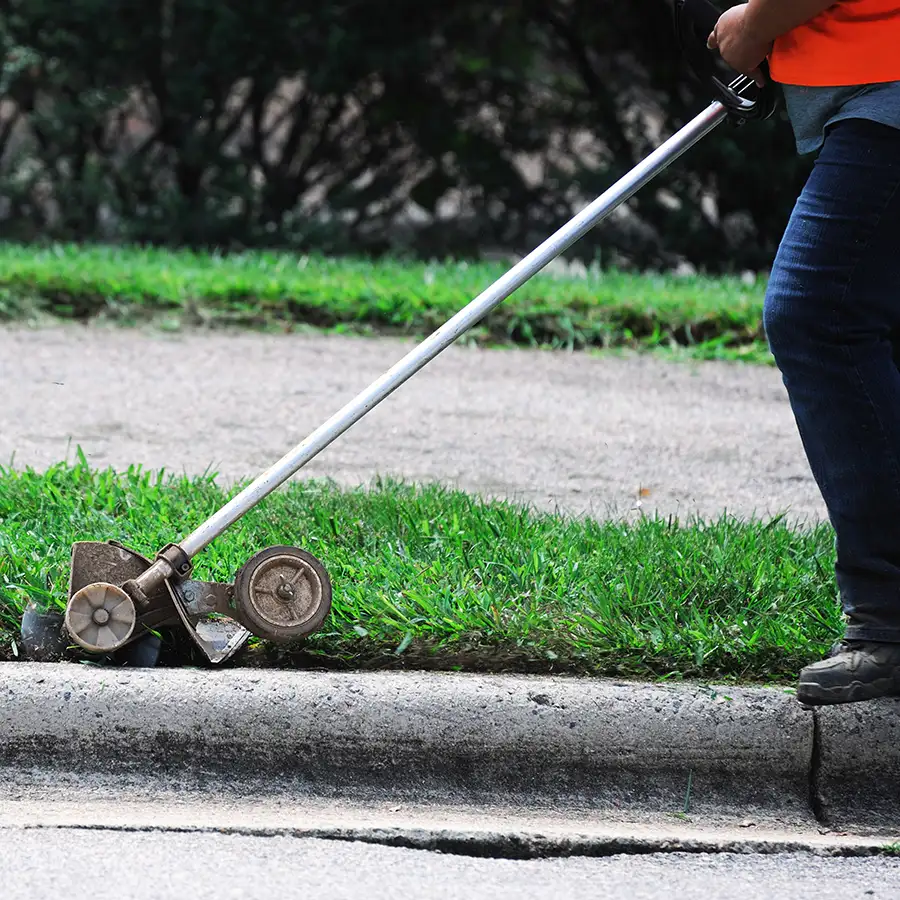 professional using an edger to maintain lawn curb appeal - edging, lawn edging - Springfield, IL