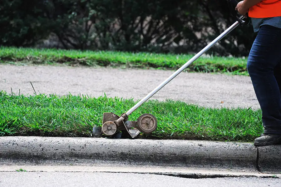 professional using an edger to maintain lawn curb appeal - edging, lawn edging - Springfield, IL